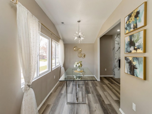 1710 Forest Ave, Des Moines, IA 50314 - dining room with an inviting chandelier, vaulted ceiling, visible vents, wood finished floors, and baseboards