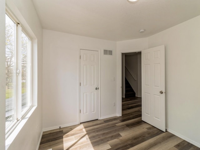 1710 Forest Ave, Des Moines, IA 50314 - unfurnished bedroom featuring wood finished floors, visible vents, and baseboards