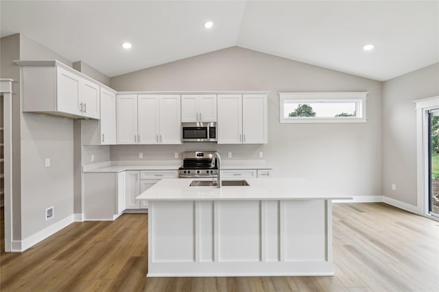 2311 N 8th Ave E, Newton, IA 50208 - kitchen with appliances with stainless steel finishes, light wood-type flooring, light countertops, vaulted ceiling, and white cabinetry