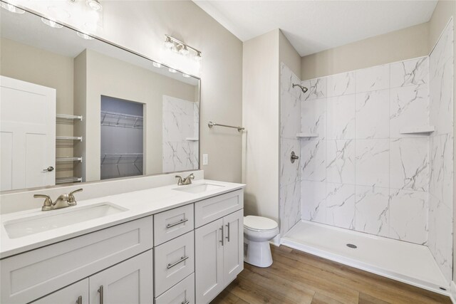 2311 N 8th Ave E, Newton, IA 50208 - bathroom with double vanity, a shower, wood finished floors, and a walk in closet