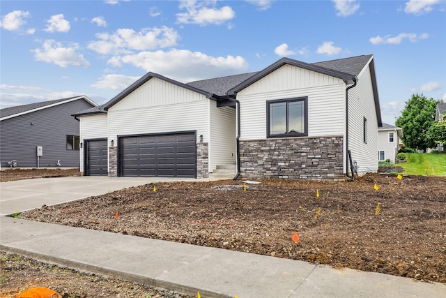2311 N 8th Ave E, Newton, IA 50208 - view of front facade featuring stone siding, an attached garage, concrete driveway, and board and batten siding