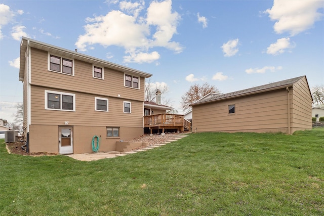 rear view of house with a wooden deck, a yard, and a patio area
