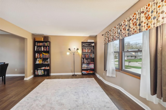 sitting room featuring baseboards and dark wood finished floors