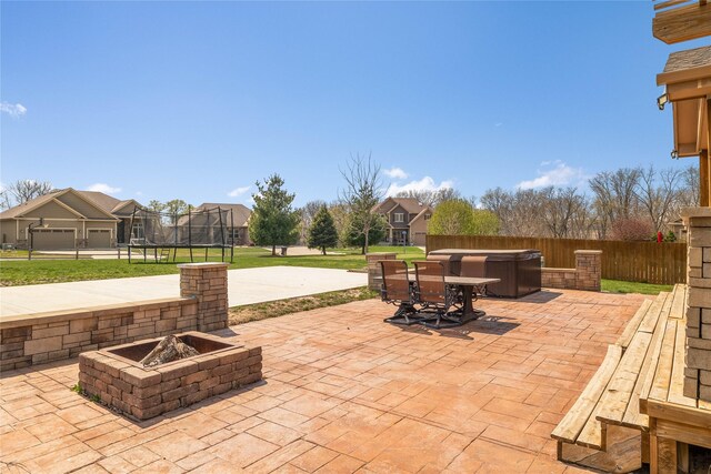 2307 SE 17th St, Ankeny, IA 50021 - view of patio with fence, an outdoor fire pit, outdoor dining space, and a trampoline