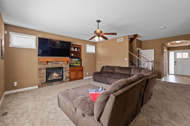 2307 SE 17th St, Ankeny, IA 50021 - living room featuring baseboards, a ceiling fan, a stone fireplace, and carpet