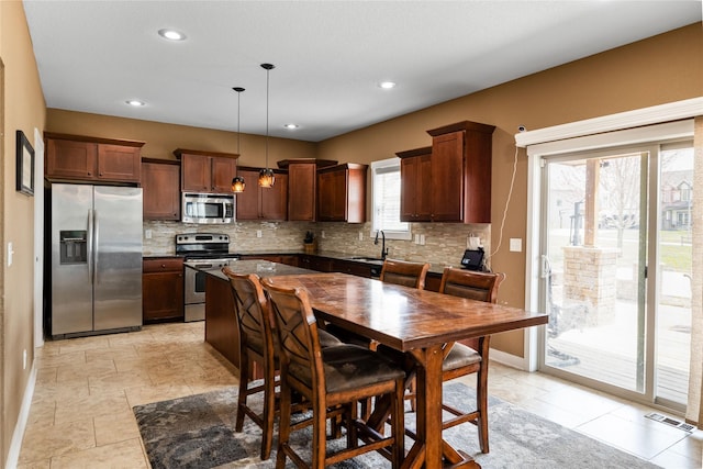 2307 SE 17th St, Ankeny, IA 50021 - kitchen with dark countertops, baseboards, backsplash, decorative light fixtures, and appliances with stainless steel finishes