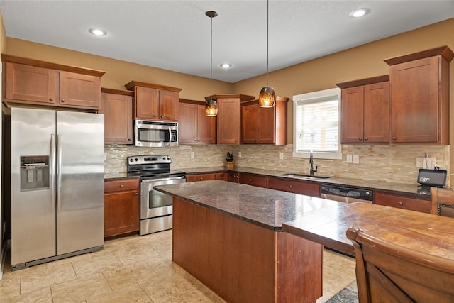 2307 SE 17th St, Ankeny, IA 50021 - kitchen with a sink, decorative backsplash, brown cabinetry, appliances with stainless steel finishes, and hanging light fixtures