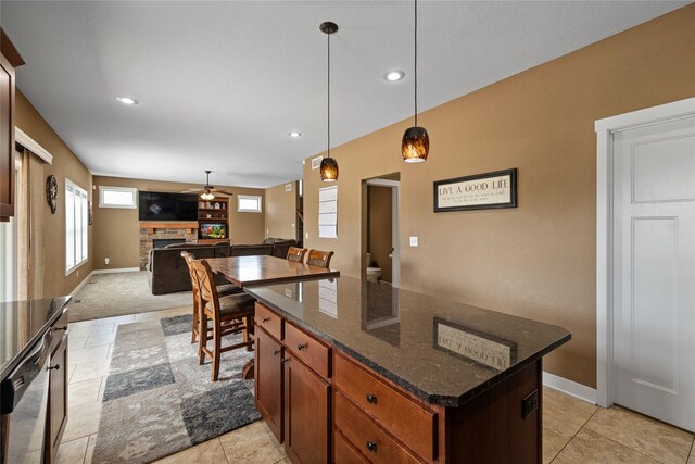 2307 SE 17th St, Ankeny, IA 50021 - kitchen featuring stainless steel dishwasher, a center island, a stone fireplace, ceiling fan, and pendant lighting