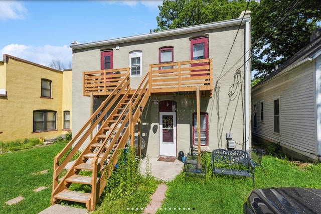 842 16th St Unit 4, Des Moines, IA 50314 - view of front of home featuring stairway, a wooden deck, a front lawn, and stucco siding