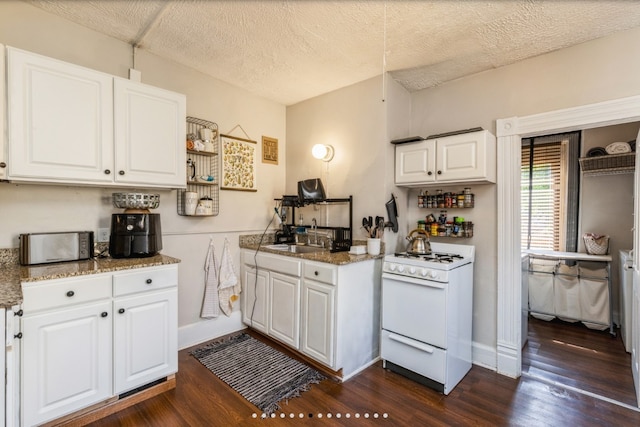 842 16th St Unit 4, Des Moines, IA 50314 - kitchen featuring a textured ceiling, a sink, dark wood-style flooring, white cabinetry, and white range with gas stovetop