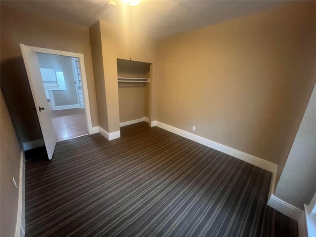 842 16th St Unit 4, Des Moines, IA 50314 - unfurnished bedroom with dark carpet, baseboards, and a closet
