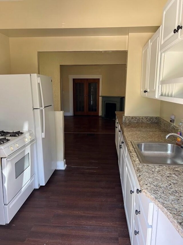 842 16th St Unit 4, Des Moines, IA 50314 - kitchen featuring french doors, a sink, white cabinetry, white range with gas stovetop, and dark wood-type flooring
