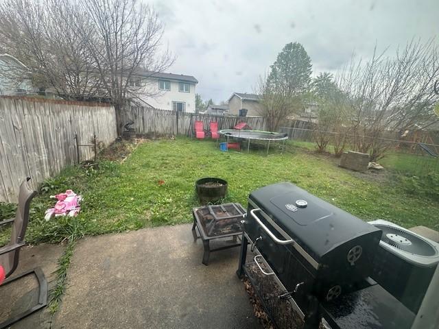 view of yard with a trampoline and a fenced backyard