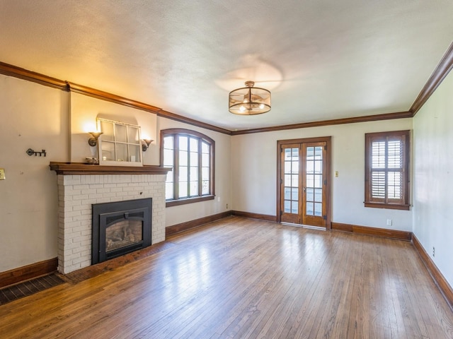 3826 Grand Ave, Des Moines, IA 50312 - unfurnished living room with hardwood / wood-style flooring, plenty of natural light, crown molding, and a brick fireplace