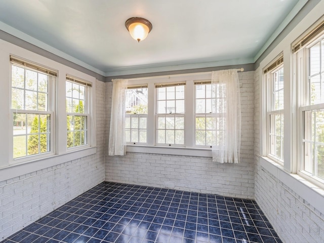 3826 Grand Ave, Des Moines, IA 50312 - unfurnished sunroom with brick wall, plenty of natural light, and tile patterned flooring