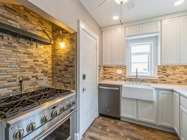 3826 Grand Ave, Des Moines, IA 50312 - kitchen featuring appliances with stainless steel finishes, tasteful backsplash, ceiling fan, dark wood-style flooring, and white cabinetry