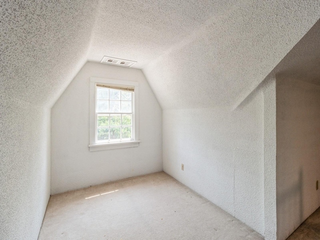 3826 Grand Ave, Des Moines, IA 50312 - additional living space with a textured ceiling, a textured wall, lofted ceiling, and carpet