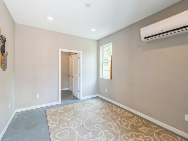 3826 Grand Ave, Des Moines, IA 50312 - empty room featuring a wall unit AC, concrete flooring, and recessed lighting