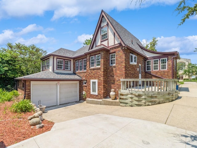 3826 Grand Ave, Des Moines, IA 50312 - view of front of home with concrete driveway, brick siding, a shingled roof, and a garage