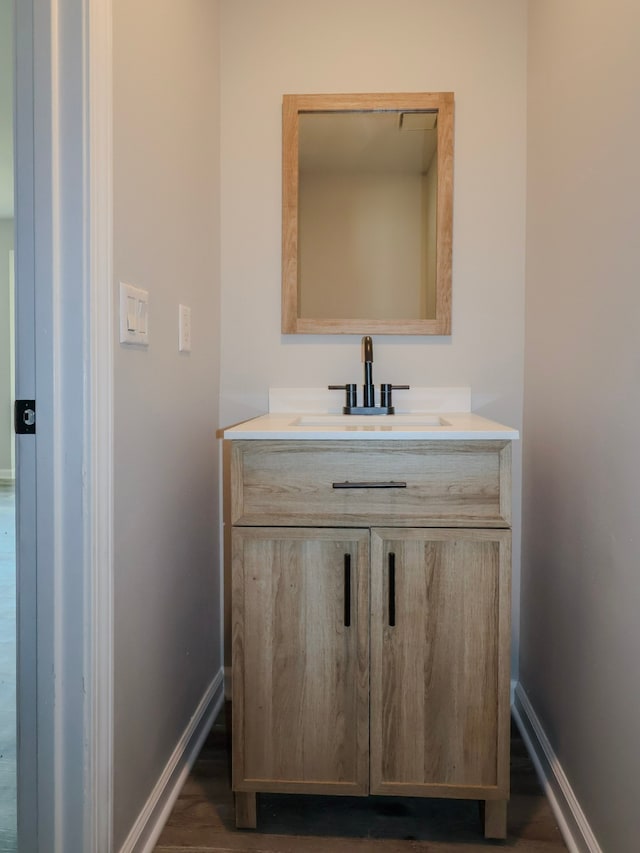 8220 Twana Dr, Urbandale, IA 50322 - bathroom featuring baseboards, wood finished floors, and vanity