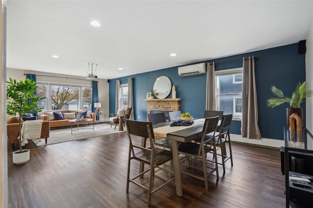 1804 E 33rd St, Des Moines, IA 50317 - dining space with an AC wall unit, dark wood-style flooring, a fireplace, recessed lighting, and baseboards
