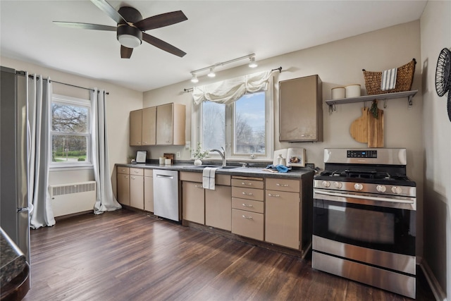 1804 E 33rd St, Des Moines, IA 50317 - kitchen with appliances with stainless steel finishes, radiator heating unit, dark countertops, ceiling fan, and dark wood-type flooring