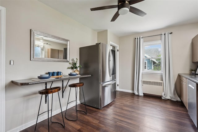 1804 E 33rd St, Des Moines, IA 50317 - kitchen with radiator, stainless steel appliances, dark wood-style flooring, a ceiling fan, and baseboards