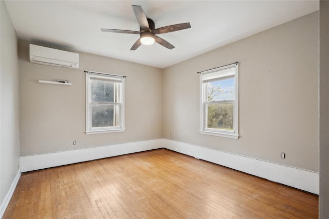 1804 E 33rd St, Des Moines, IA 50317 - empty room with a wall unit AC, wood-type flooring, ceiling fan, and baseboards