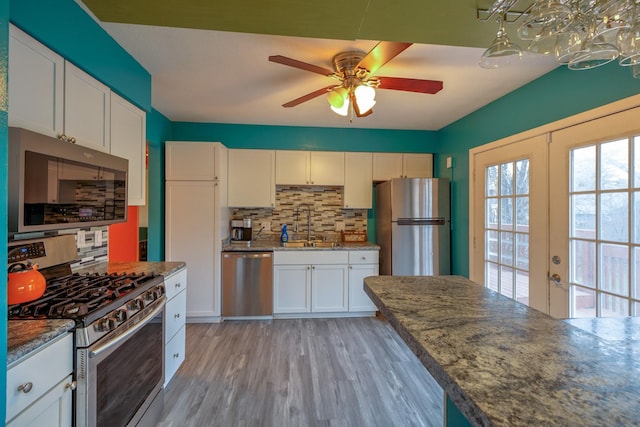 310 E Emma Ave, Des Moines, IA 50315 - kitchen with appliances with stainless steel finishes, ceiling fan, tasteful backsplash, and white cabinets