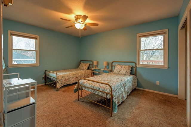310 E Emma Ave, Des Moines, IA 50315 - bedroom featuring carpet flooring, multiple windows, baseboards, and a ceiling fan