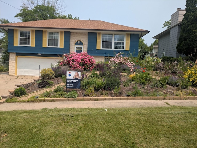 310 E Emma Ave, Des Moines, IA 50315 - split foyer home with brick siding, an attached garage, a front yard, and concrete driveway
