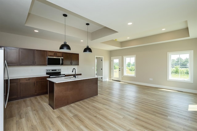 1202 Westview Dr, Huxley, IA 50124 - kitchen featuring appliances with stainless steel finishes, a raised ceiling, a sink, light countertops, and light wood-style flooring