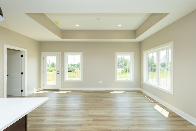 1202 Westview Dr, Huxley, IA 50124 - unfurnished living room featuring a tray ceiling, baseboards, light wood-style flooring, and recessed lighting