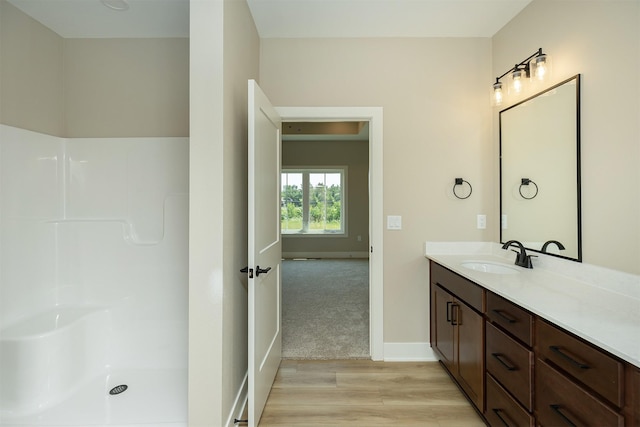 1202 Westview Dr, Huxley, IA 50124 - bathroom with wood finished floors, vanity, baseboards, and a shower