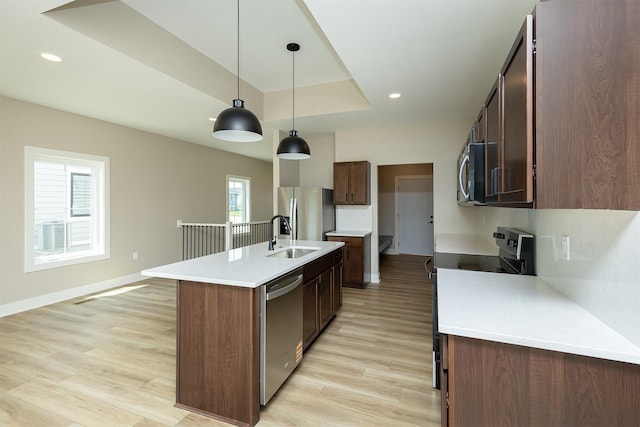 1206 Westview Dr, Huxley, IA 50124 - kitchen with appliances with stainless steel finishes, a sink, light wood-type flooring, a center island with sink, and light countertops
