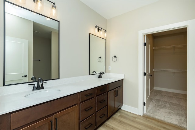 1208 Westview Dr, Huxley, IA 50124 - full bath featuring double vanity, wood finished floors, a walk in closet, and baseboards