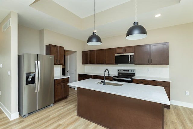 1212 Westview Dr, Huxley, IA 50124 - kitchen featuring appliances with stainless steel finishes, a sink, light wood-style flooring, dark brown cabinets, and light countertops