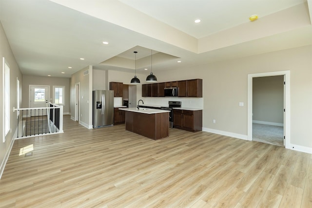 1212 Westview Dr, Huxley, IA 50124 - kitchen with stainless steel appliances, a raised ceiling, open floor plan, light countertops, and recessed lighting