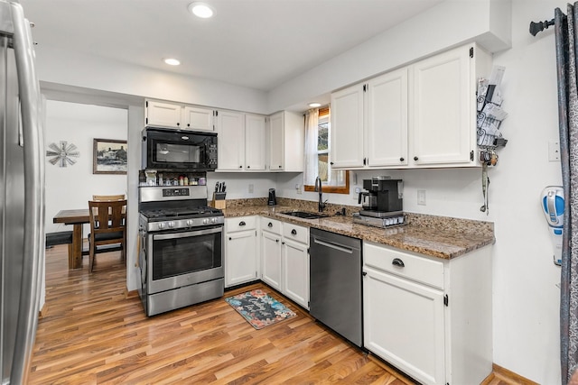 4830 70th Pl, Urbandale, IA 50322 - kitchen with appliances with stainless steel finishes, a sink, recessed lighting, light wood finished floors, and white cabinets