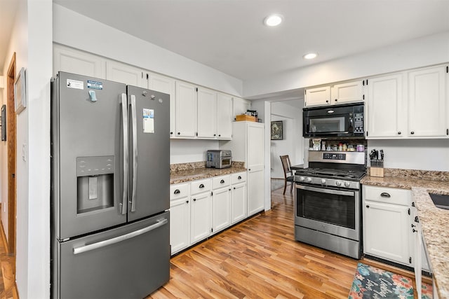 4830 70th Pl, Urbandale, IA 50322 - kitchen with appliances with stainless steel finishes, white cabinetry, light wood-style flooring, recessed lighting, and light stone countertops