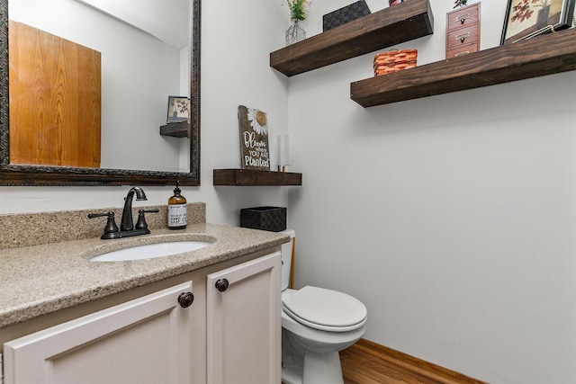 4830 70th Pl, Urbandale, IA 50322 - half bathroom featuring wood finished floors, toilet, and vanity