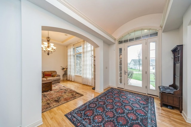 9289 Winterberry Ct, West Des Moines, IA 50266 - foyer featuring arched walkways, wood finished floors, a healthy amount of sunlight, and baseboards