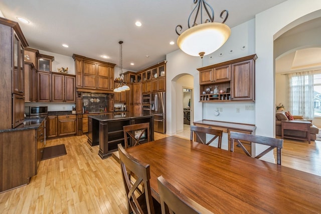 9289 Winterberry Ct, West Des Moines, IA 50266 - dining space featuring light wood-type flooring, arched walkways, and recessed lighting