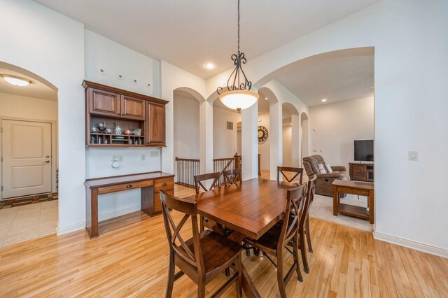 9289 Winterberry Ct, West Des Moines, IA 50266 - dining area featuring light wood finished floors, baseboards, and arched walkways