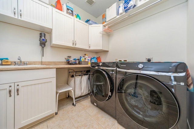 9289 Winterberry Ct, West Des Moines, IA 50266 - clothes washing area with visible vents, a sink, light tile patterned floors, washer and dryer, and cabinet space