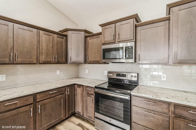 4901 NW 15th St, Ankeny, IA 50023 - kitchen with appliances with stainless steel finishes, tasteful backsplash, light stone counters, and light wood-style flooring