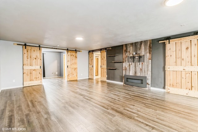 4901 NW 15th St, Ankeny, IA 50023 - unfurnished living room with baseboards, wood finished floors, and a barn door