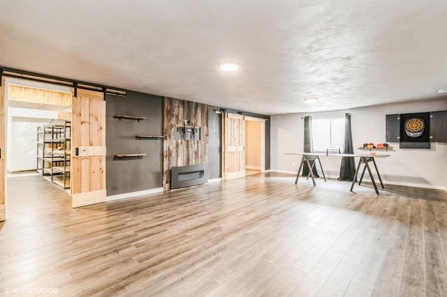 4901 NW 15th St, Ankeny, IA 50023 - living room featuring a barn door, wood finished floors, and baseboards