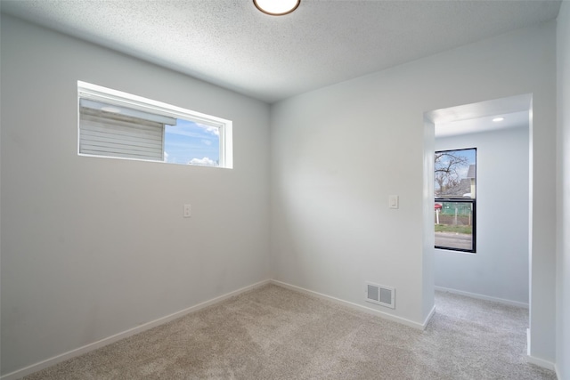 312 N 3rd Ave, Marshalltown, IA 50158 - carpeted empty room with baseboards, visible vents, and a textured ceiling