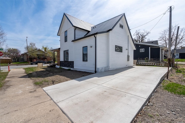 312 N 3rd Ave, Marshalltown, IA 50158 - view of side of home featuring concrete driveway and metal roof